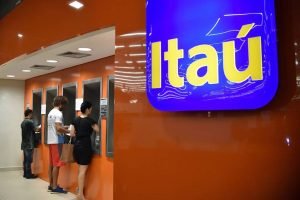 Imagem colorida mostra agência do Itaú e clientes em caixa eletrônico — Foto: 1