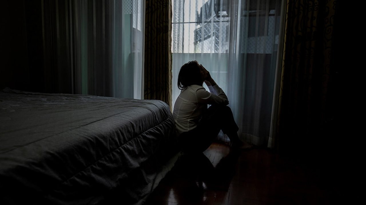 Sad young woman sitting on the bed in the bedroom, People with d Foto: Title