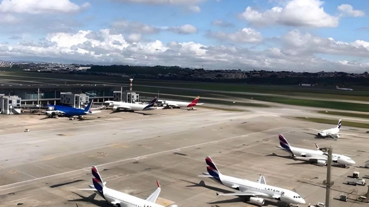 Pista de aeroporto com aeronaves estacionadas, o céu está azul com nuvens — Foto