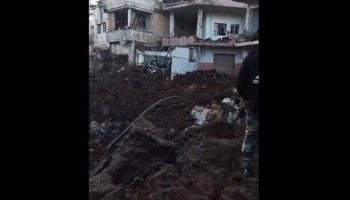 Pessoas inspecionam os danos causados por um ataque — Foto: Pessoas inspecionam