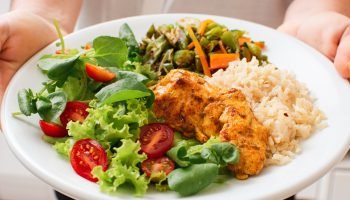 Foto colorida de pessoa segurando um prato de comida saudável - Exagerou? — Foto