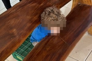 crianca-prende-cabeca-banco-madeira