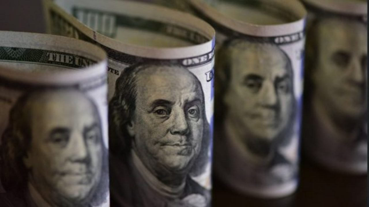 Foto: 1 de 1 Imagem colorida de maços de notas de dólar norte-americano - Foto: