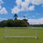 empty-soccer-goal-green-grass-field-blue-sky