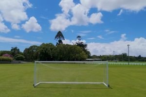 empty-soccer-goal-green-grass-field-blue-sky