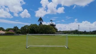 empty-soccer-goal-green-grass-field-blue-sky