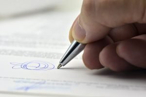 Foto: 1 de 1 Imagem colorida mostra mão segurando caneta e escrevendo assinatura