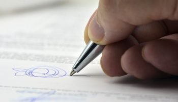 Foto: 1 de 1 Imagem colorida mostra mão segurando caneta e escrevendo assinatura