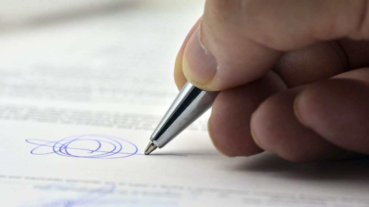 multa-de-transito Foto: 1 de 1 Imagem colorida mostra mão segurando caneta e escrevendo assinatura