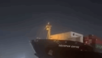 O porta-contêineres Seaspan Empire manobra no canal entre Santos e Guarujá antes